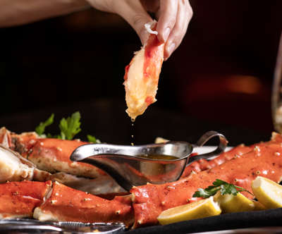 Dipping crab leg into butter
